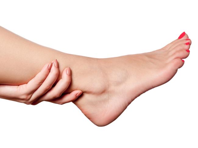 Closeup view of a young woman with pain on leg. isolated on white background.