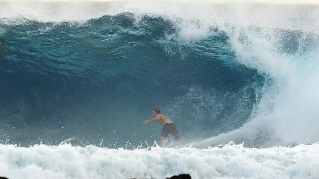 A surfer is seen at Snapper Rocks on the Gold Coast , Thursday February 21, 2019. Huge swells and high tides are set to pummelling south-east Queensland beaches over the coming days as Cyclone Oma tracks towards the Queensland coast. Photo: Dave Hunt/AAP.