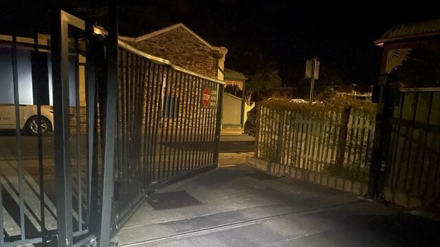 The busted-open gates at the rear of the Lexus dealership on West Terrace. Picture: SAPOL