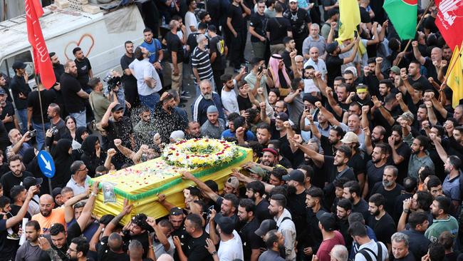 Mourners toss rice over the coffin of person killed after hundreds of paging devices exploded across Lebanon. Picture: AFP