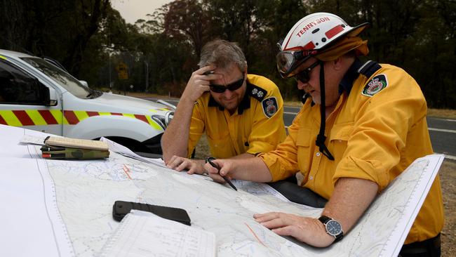 RFS commanders discuss a plan to burn containment lines around properties north of Sydney. Picture: AAP