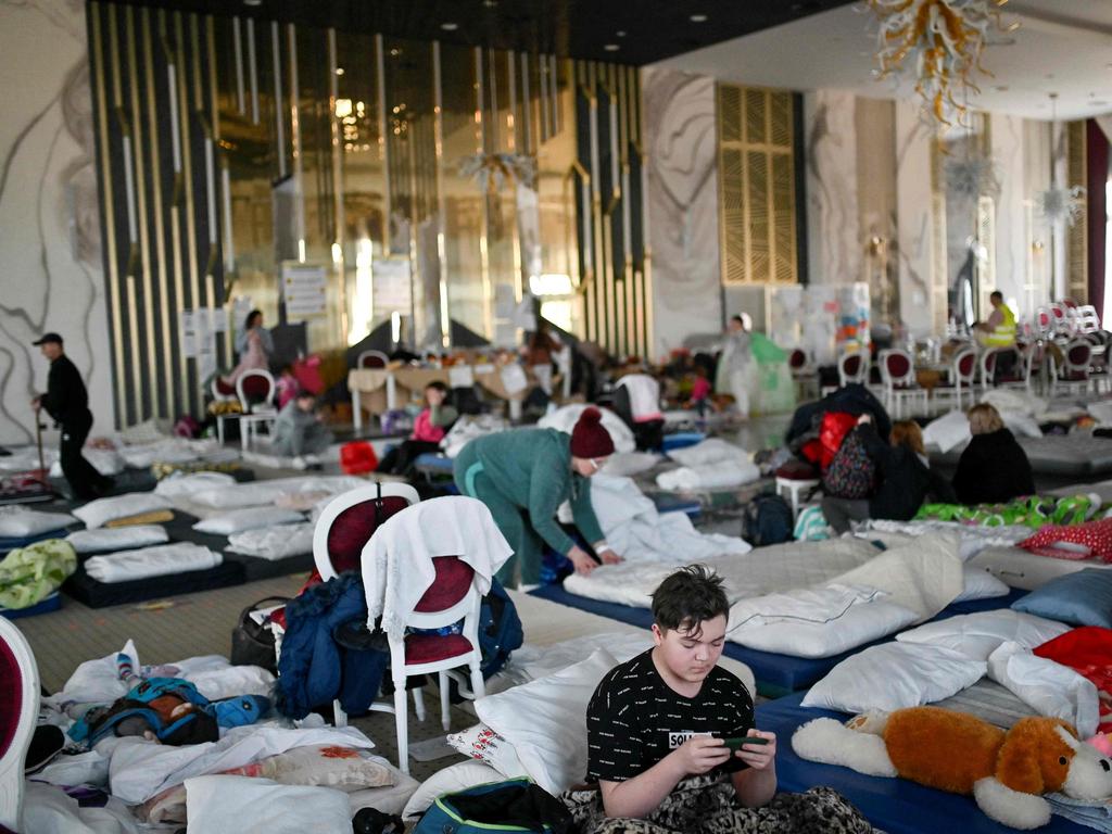 Ukrainian refugees rest at a hotel ballroom converted into a makeshift shelter in the town of Suceava, Romania. Picture: Armend Nimani/AFP