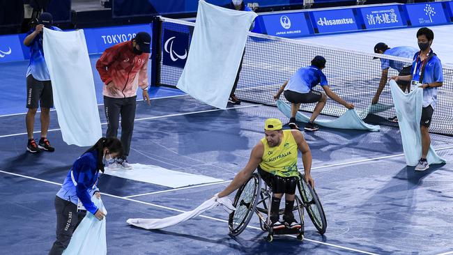 Dylan Alcott helps the volunteers dry the court. Photo by Buda Mendes/Getty Images