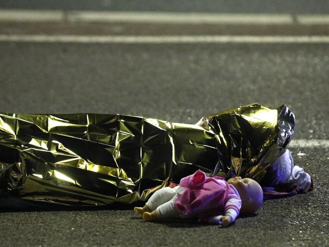 A covered body is seen next to a child’s doll. Picture: Eric Gaillard/Reuters