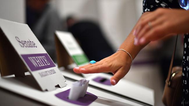 A voter drops her ballot paper into the ballot box at the Lilly Pilly polling booth during the general election in 2019.