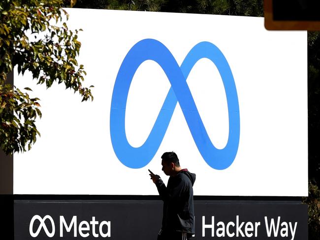 (FILES) In this file photo taken on October 28, 2021 a pedestrian walks in front of a new logo and the name 'Meta' on the sign in front of Facebook headquarters in Menlo Park, California. - Facebook's parent company Meta said February 25, 2022 that Russia will hit its services with restrictions after the social media giant refused authorities' order to stop fact-checkers and content warning labels on its platforms. (Photo by JUSTIN SULLIVAN / GETTY IMAGES NORTH AMERICA / AFP)