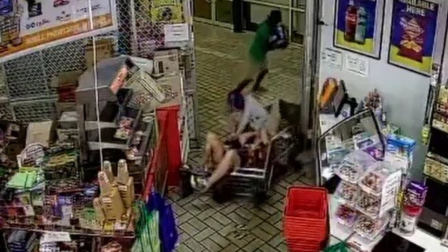 A CCTV still of the incident. The Winnellie Supermarket shop owner is allegedly knocked to the ground by two men as they run from the premises with alcohol. Picture: Supplied