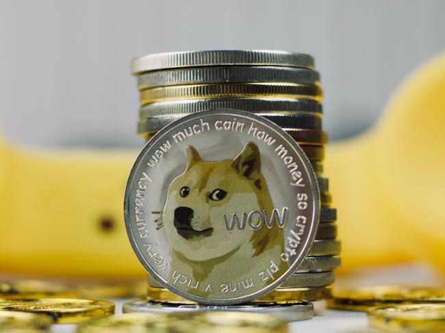 Digital currency physical metal dogecoin coin. Yellow phone communication concept.  Picture: istock