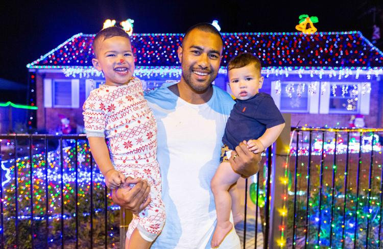 Sione Ala with Soni and George in front of their home on Galston Rd, Hornsby Heights. Hornsby Heights has some of the best Christmas lights in Sydney. Picture: AAP IMAGE/Jordan Shields