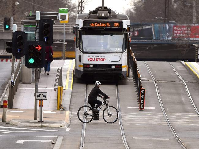 A person crosses an empty street in Melbourne on August 27, 2021 as the city experiences it's sixth lockdown while battling an outbreak of the Delta variant of the coronavirus. (Photo by William WEST / AFP)