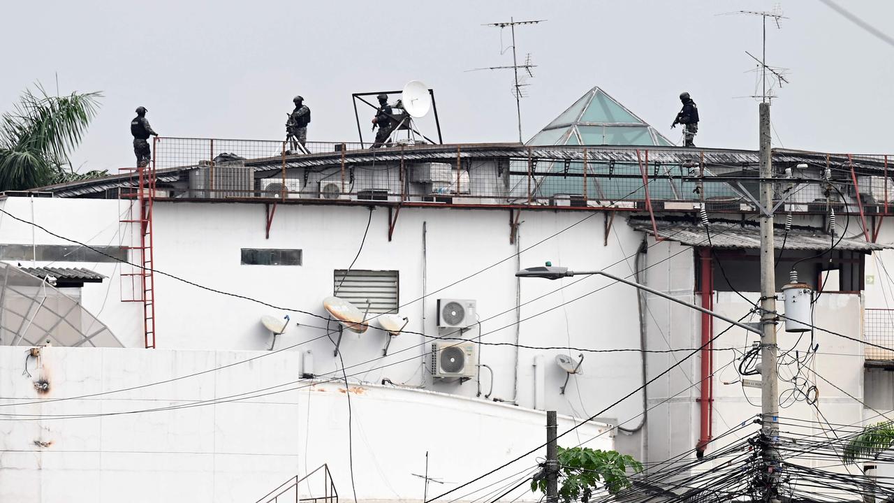 An Ecuadorean police squad approach the premises of Ecuador's TC television channel after unidentified gunmen burst into the state-owned television studio live on air. Picture: Marcos Pin / AFP