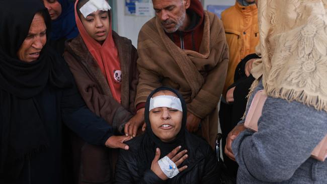 An injured woman is comforted as she mourns relatives killed in Israeli airstrikes. Picture: AFP