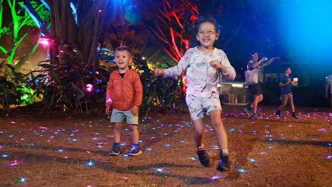 Coen Salmon, 2, and Lawan Salmon, 4, have fun running through the colourful lights at Reef Light – Illuminate the Tropics, before wet weather sets in. Picture: Brendan Radke