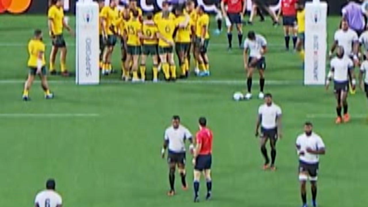 New Zealand referee Ben O’Keeffe gives a low-five to a Fijian after they scored and went out to a 21-12 lead over the Wallabies.