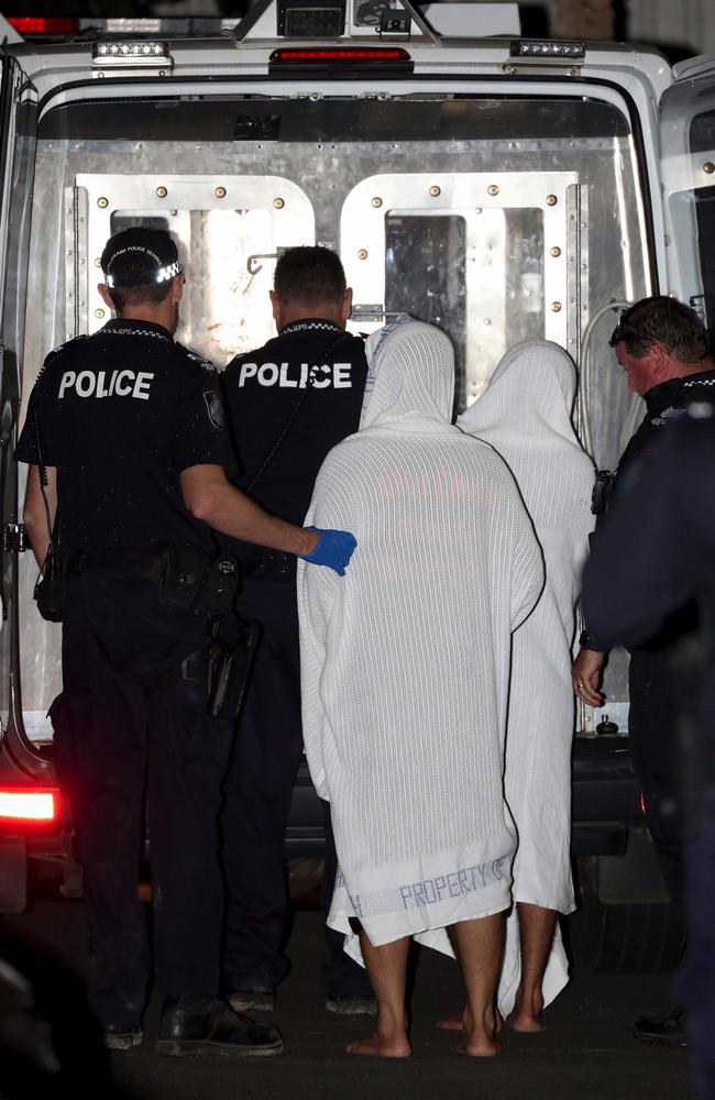 Two Vietnamese asylum seekers being led into a police van. Picture: Mark McCormack