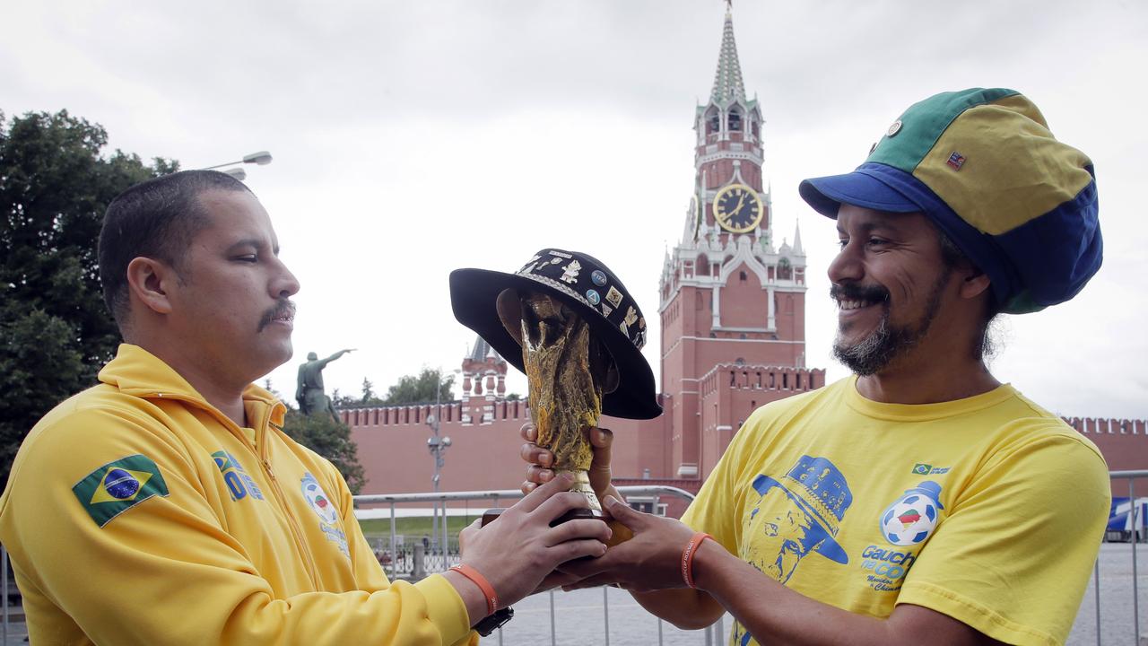 Brazilian fans hold a copy of the World Cup trophy near the Kremlin in Moscow.