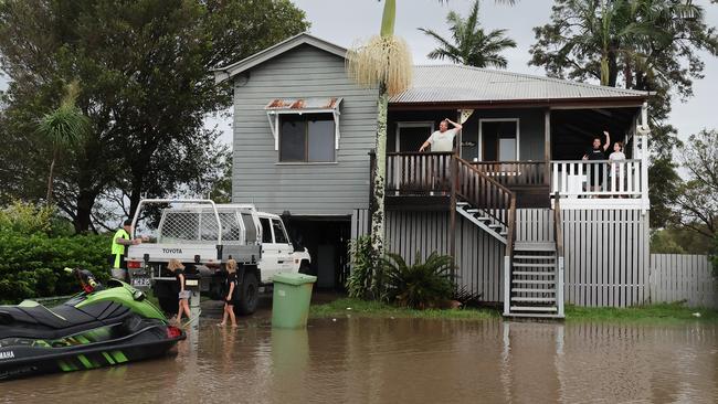 Flooding on the Gold coast in the aftermath of Cyclone Alfred. Stapylton homes surrounded by floodwaters..Leigh Kerslake and family watch the water with their jetski tied to the letterbox Picture Glenn Hampson