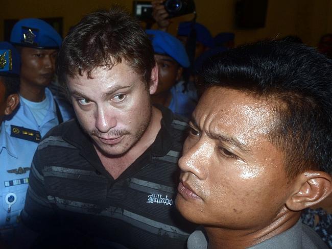 Heavily guarded ... Matt Lockley is taken into the airport after being arrested on arrival at Ngurah Rai airport.