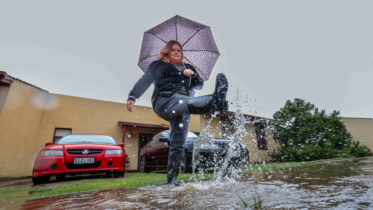 Denise Palmer of Semaphore Park gets her feet wet outside her home. Picture: Russell Millard Photography