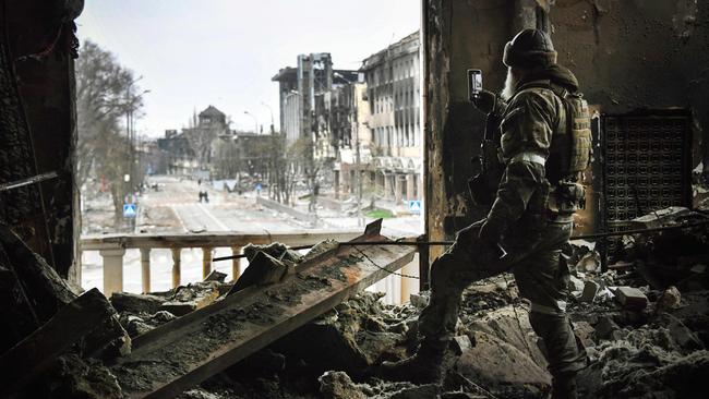 A Russian soldier patrols at the Mariupol drama theatre, bombed last March as Ukrainians sheltered inside. Picture: AFP.