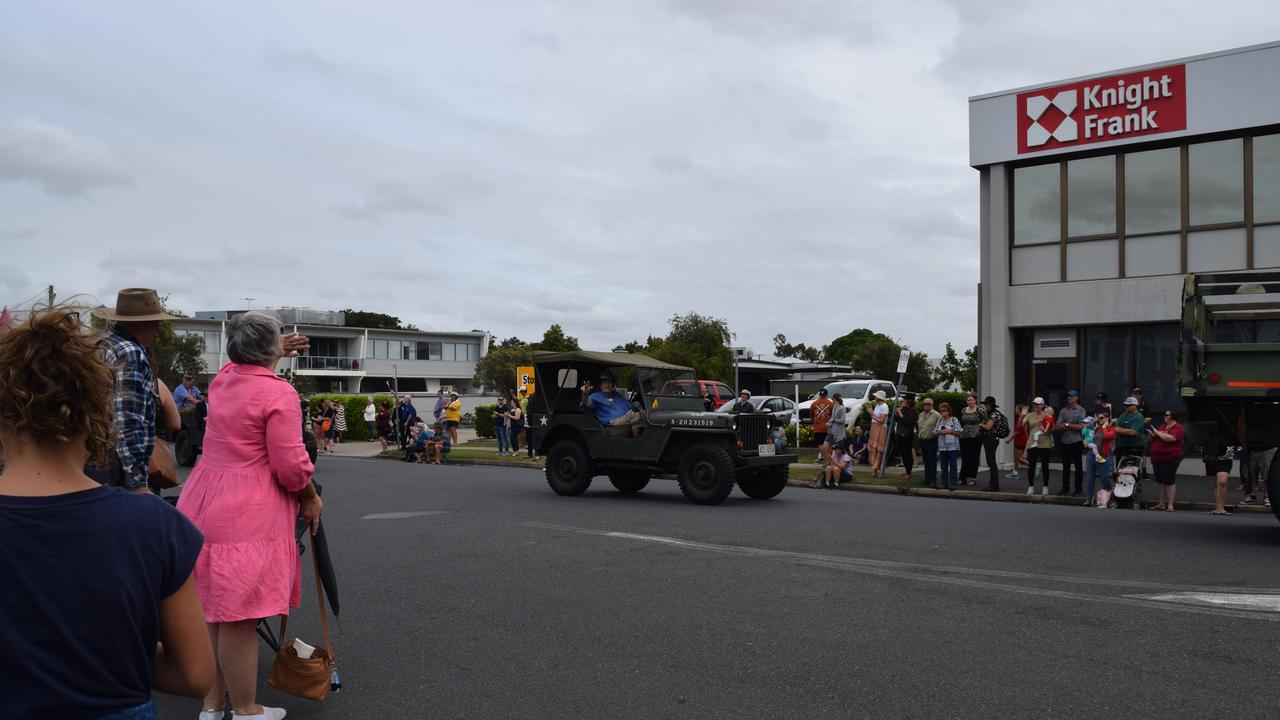 A person in the march waving to an onlooker.