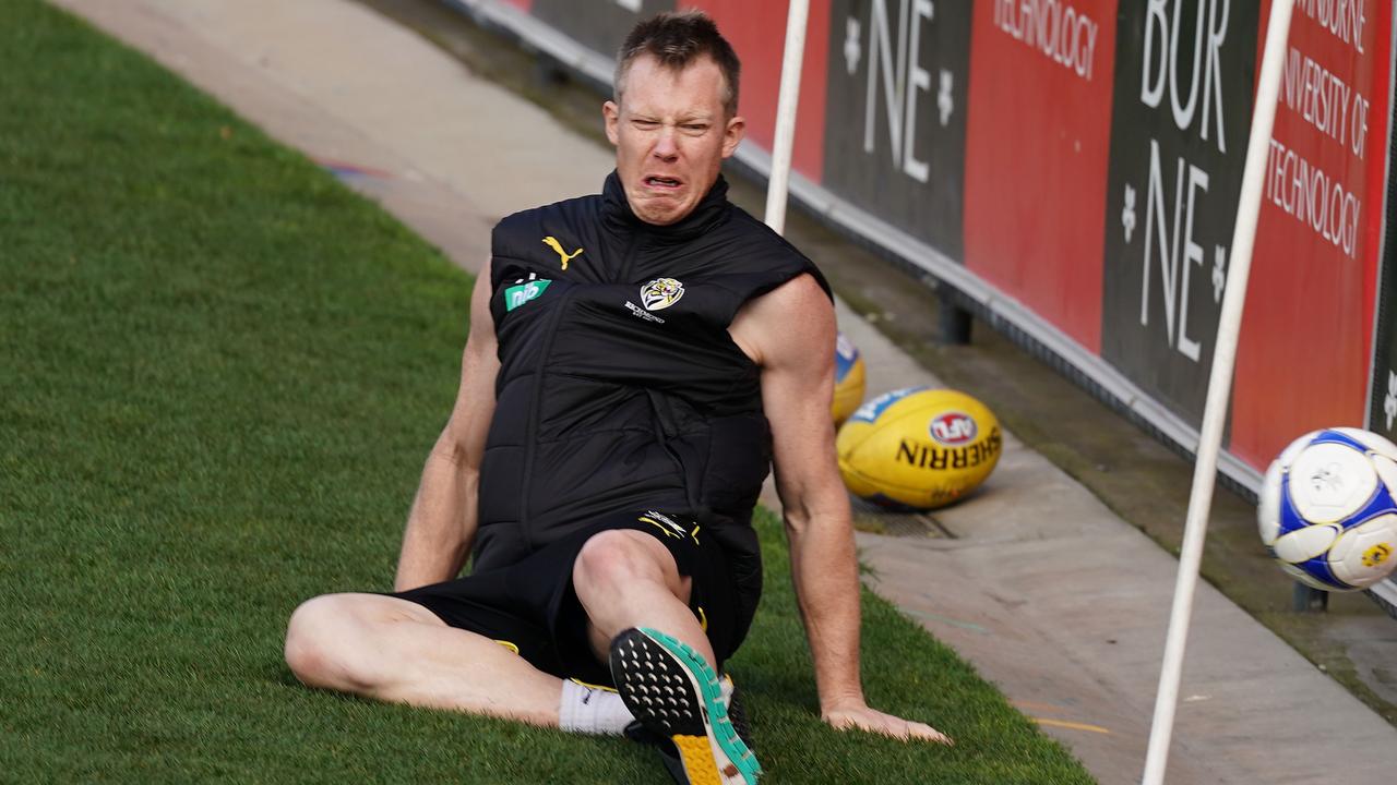 Jack Riewoldt falls over as he attempts to stop a soccer ball at Richmond training. (AAP Image/Scott Barbour)
