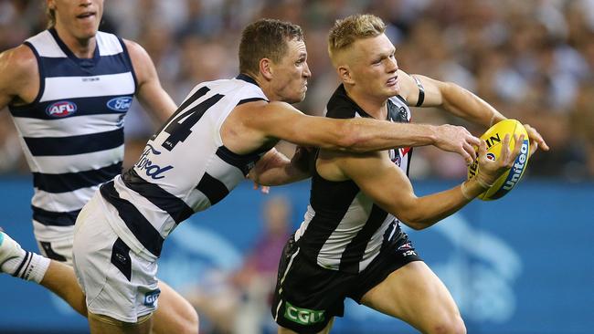 Collingwood’s Adam Treloar is under pressure from Joel Selwood. Picture: Michael Klein.