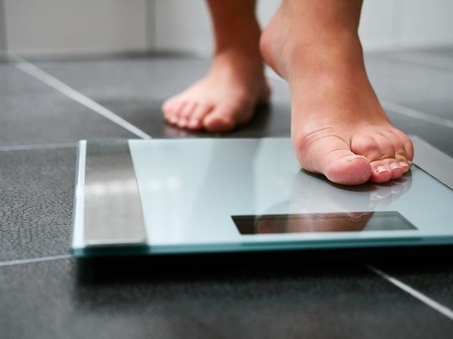 Female bare feet with weight scale in the bathroom, scales generic