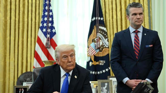 President Donald Trump and Secretary of Defence Pete Hegseth listen during an event in the Oval Office.