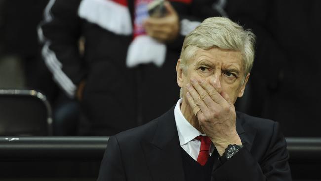 Arsenal's manager Arsene Wenger covers his face.