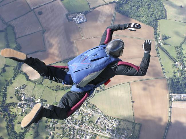 Skydiver in freefall high up in the air on a sunny day