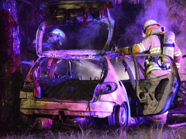 Firemen douse the wrecked vehicle this morning. Picture: John Grainger