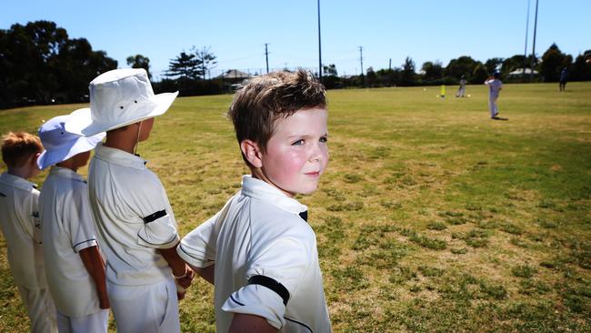 Jacob Knight, 8, with Wanervale wears a black armband to honour Phil Hughes as he watches his team batting.