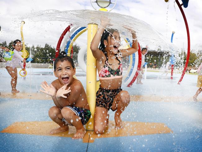 Samson Ava and his sister Olivia Ava cooling off at Cirillo Water Park splash playground at Middleton Grange in Sydney’s west. Picture: Richard Dobson