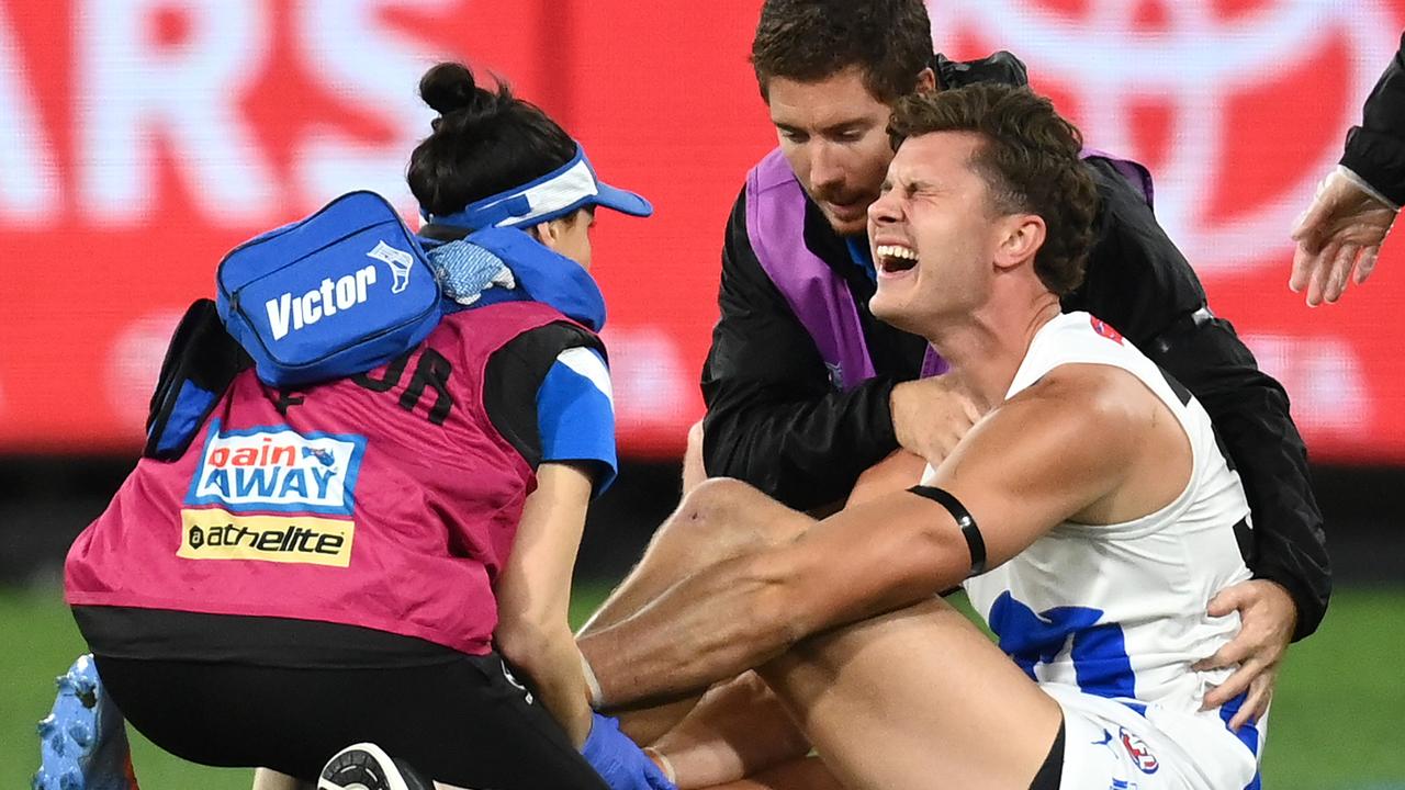 MELBOURNE, AUSTRALIA - APRIL 29: Charlie Comben of the Kangaroos is attended to by trainers during the round seven AFL match between Melbourne Demons and North Melbourne Kangaroos at Melbourne Cricket Ground, on April 29, 2023, in Melbourne, Australia. (Photo by Quinn Rooney/Getty Images)