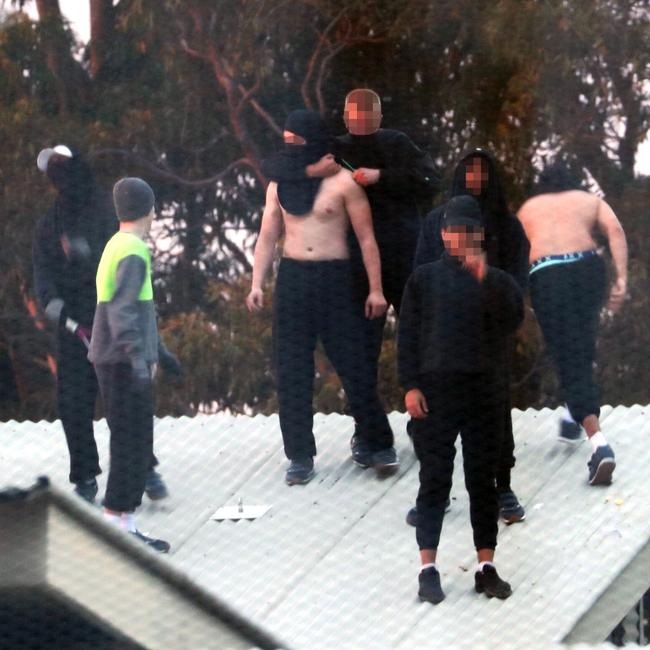 Inmates from the Frank Baxter Juvenile corrections centre Kariong taunt police from the roofs of various buildings. Some are armed with poles tennis rackets ect. Picture: John Grainger