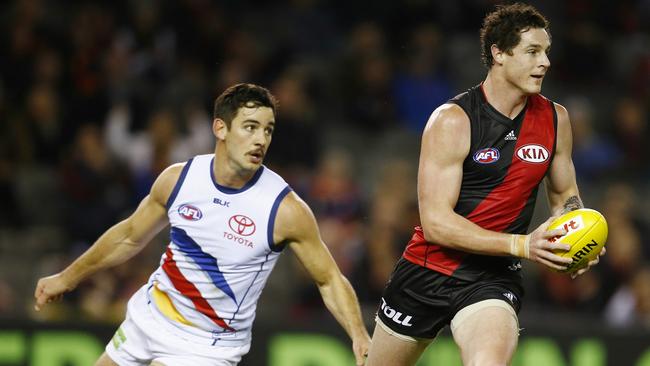 Round 20. Essendon vs Adelaide Crows at Etihad Stadium. Jake Carlisle clears infront of Taylor Walker . Pic: Michael Klein