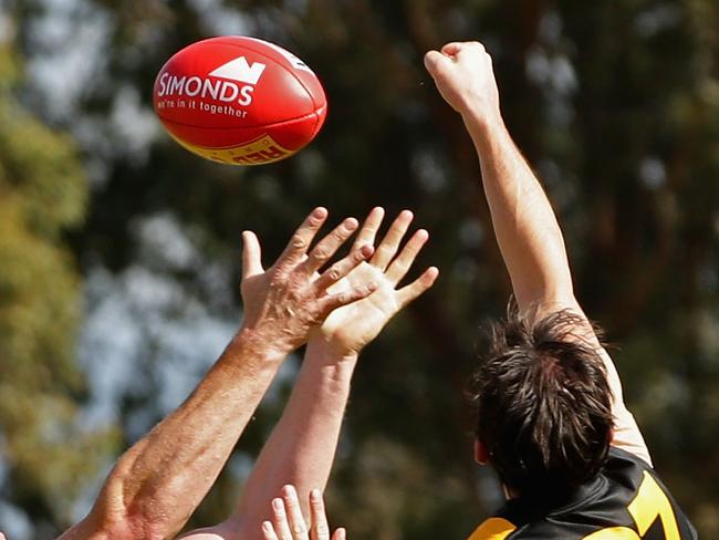 Former AFL player Barry Hall competes against three opponents and wins a free kick during the match between Broadford and Lancefield at the Harley Hammond Reserve in Broadford on Sunday 7th April, 2013.