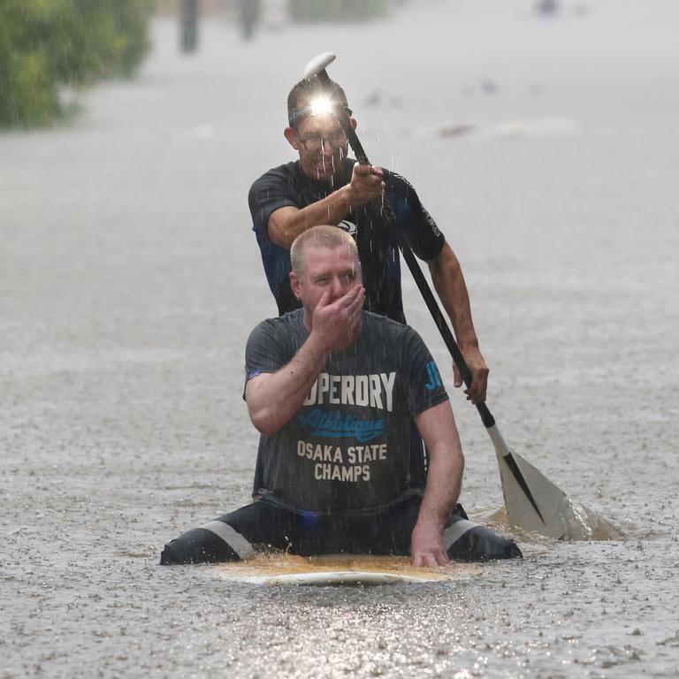 Dean Muller rescues Corey Gibson from floodwaters on Victoria St, Windsor. Picture: Anthony Reginato