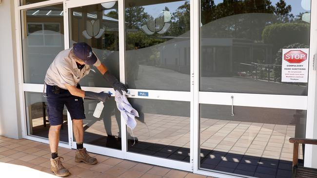 A staff member at Allambie Heights Village aged care facility uses bleach to clean the handrails and door handles as a precaution to reduce the spread of COVID-19. Picture: Nikki Short