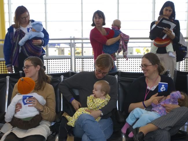 NOVEMBER 21, 2006: Protesting mothers breast feed their babies in mass inside Ronald Reagan National Airport in Washington, DC, 21/11/06, in front of the Delta Airlines ticket counter. The mothers were protesting as a result of a prior incident in which Emily Gillette was breast feeding her child on a Delta Airlines flight prior to take off when the flight attendant told her to cover her breast feeding child with a blanket. The flight attendant had Gillette and her family removed from the plane when the mother declined to cover her baby. USA / Demonstration / Women