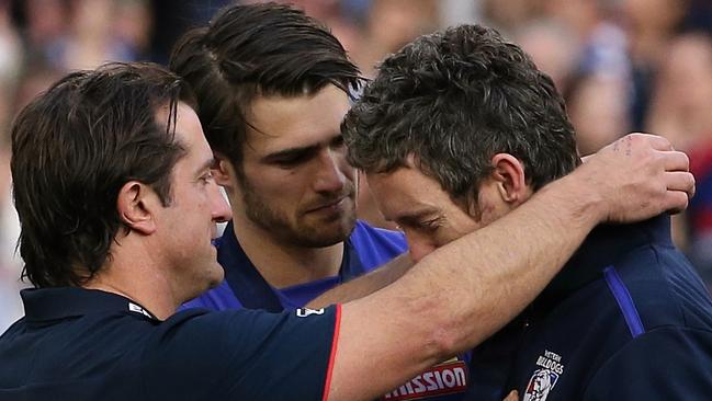 Luke Beveridge puts his premiership medal over Bob Murphy's neck on the podium with Easton Wood.