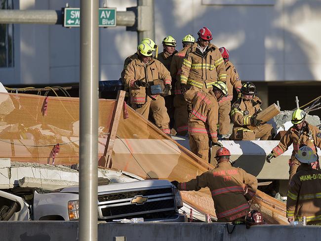 Miami-Dade Fire Rescue firefighters work on a brand new pedestrian bridge that collapsed in front of Florida International University. Picture: AP