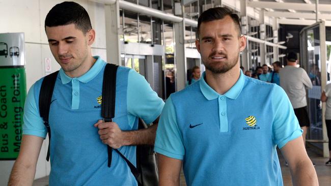 Socceroos Tom Rogic (left) and Bailey Wright arrive back in Sydney on Sunday following the flight from Honduras.