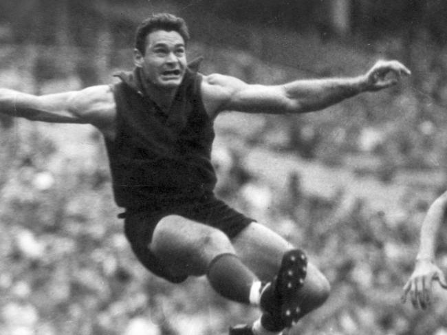 1965? Ron Barassi after he had goaled with a spectacular kick from the boundary. Racing in are Bill Harrington and Barry Ion. Melbourne v Footscray. MCG. HWT ARCHIVAL NEGATIVE. Picture: BRUCE HOWARD.