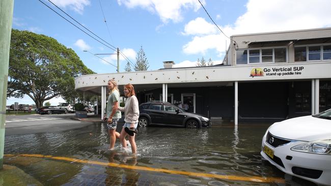 Flooding from the King tide at Budds Beach at Surfers Paradise was made worse by the approaching storm system. Holden hunt and Taylah Jay walk through the floodwaters in Pine Ave. Picture Glenn Hampson
