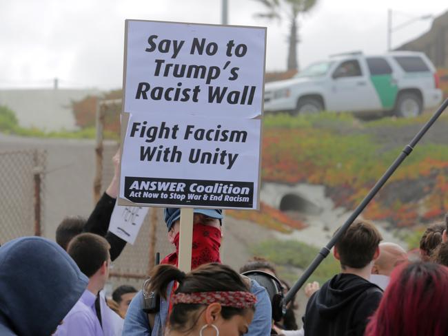 Pro-migrant demonstrators rally at the west end of the US-Mexico border as Border Patrol officers monitor the demonstration. picture; Bill Wechter/Getty Images/AFP