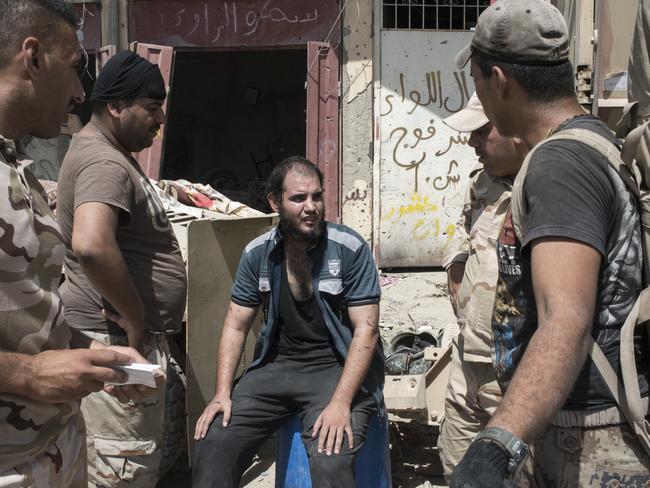 An Iraqi man who has fled the Islamic State controlled Old City of west Mosul where heavy fighting continues is questioned and searched. Picture: Martyn Aim/Getty Images