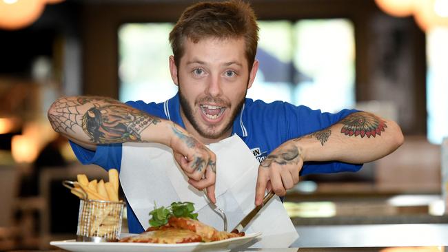 A hungry Luke Christensen devours an oversized chicken schnitzel from the Mawson Lakes Hotel. Picture: Roy Van Der Vegt