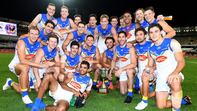 Gold Coast Suns players pose for a team photo with the QClash cup.